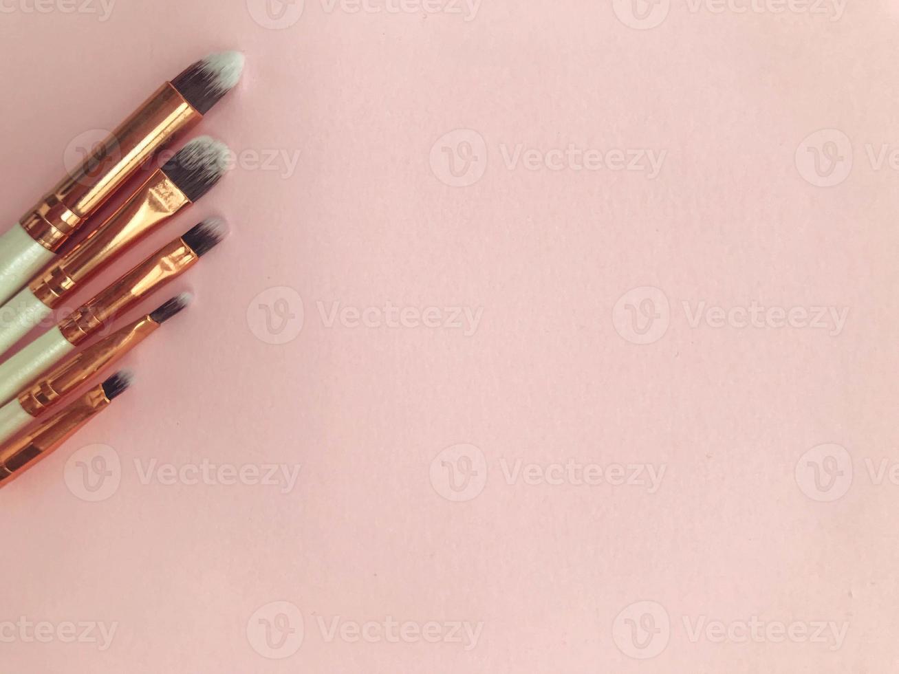 makeup brushes on a pink background. different brushes for applying textures to the face. keg eyeshadow brush, flat lipstick brush, fine eyeliner brush photo