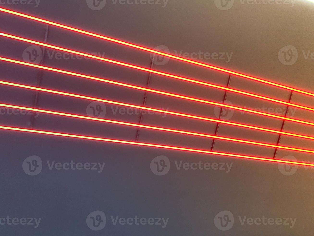 Texture of red glowing bright neon LED multicolored laser abstract stripes and lines from parallel lamps. The background photo