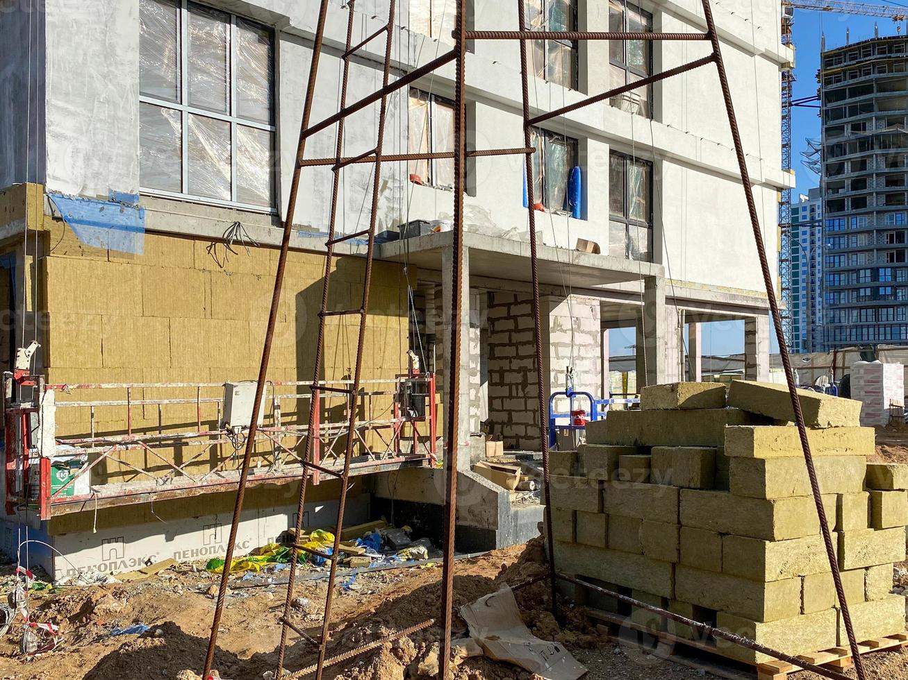 acabado de la fachada de un edificio monolítico de hormigón y bloques de silicato de gas con aislamiento de lana mineral durante la construcción y renovación de la casa con materiales modernos foto