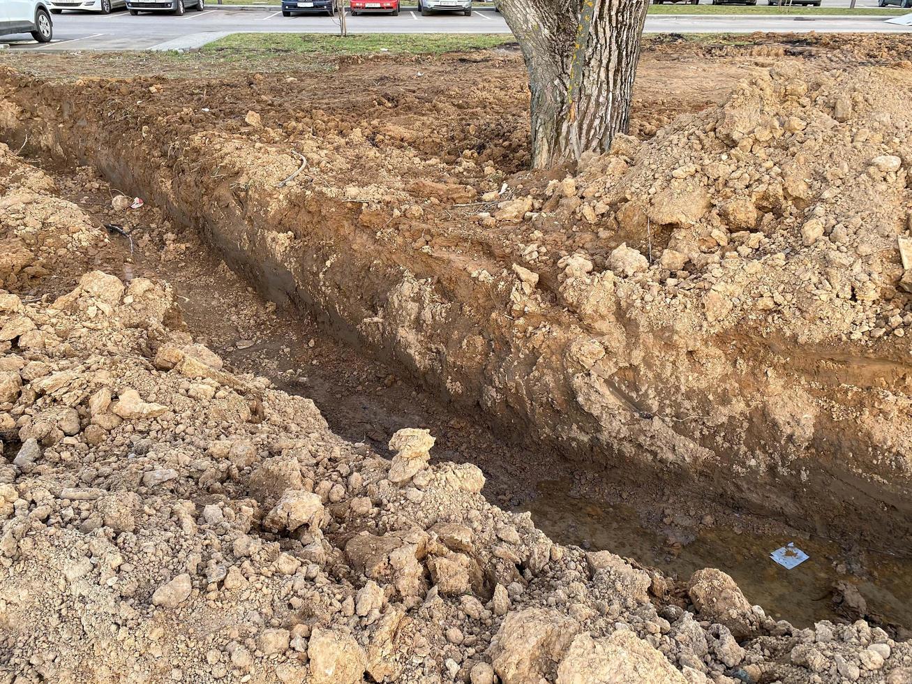 An excavated pit is a ditch for laying cables and wires with pipes under the ground during the construction and repair of houses in the city of the megalopolis photo