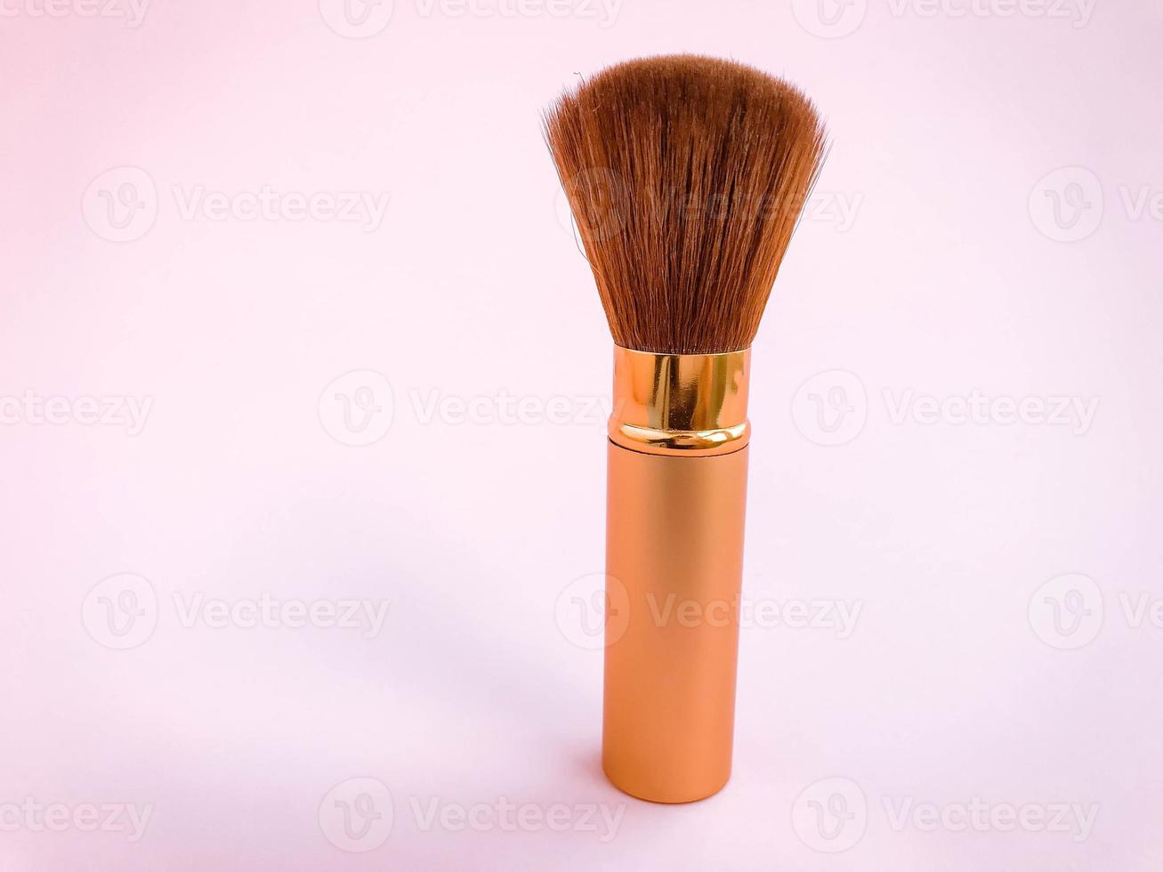 Make up brushes with powder splashes isolated on pink background photo