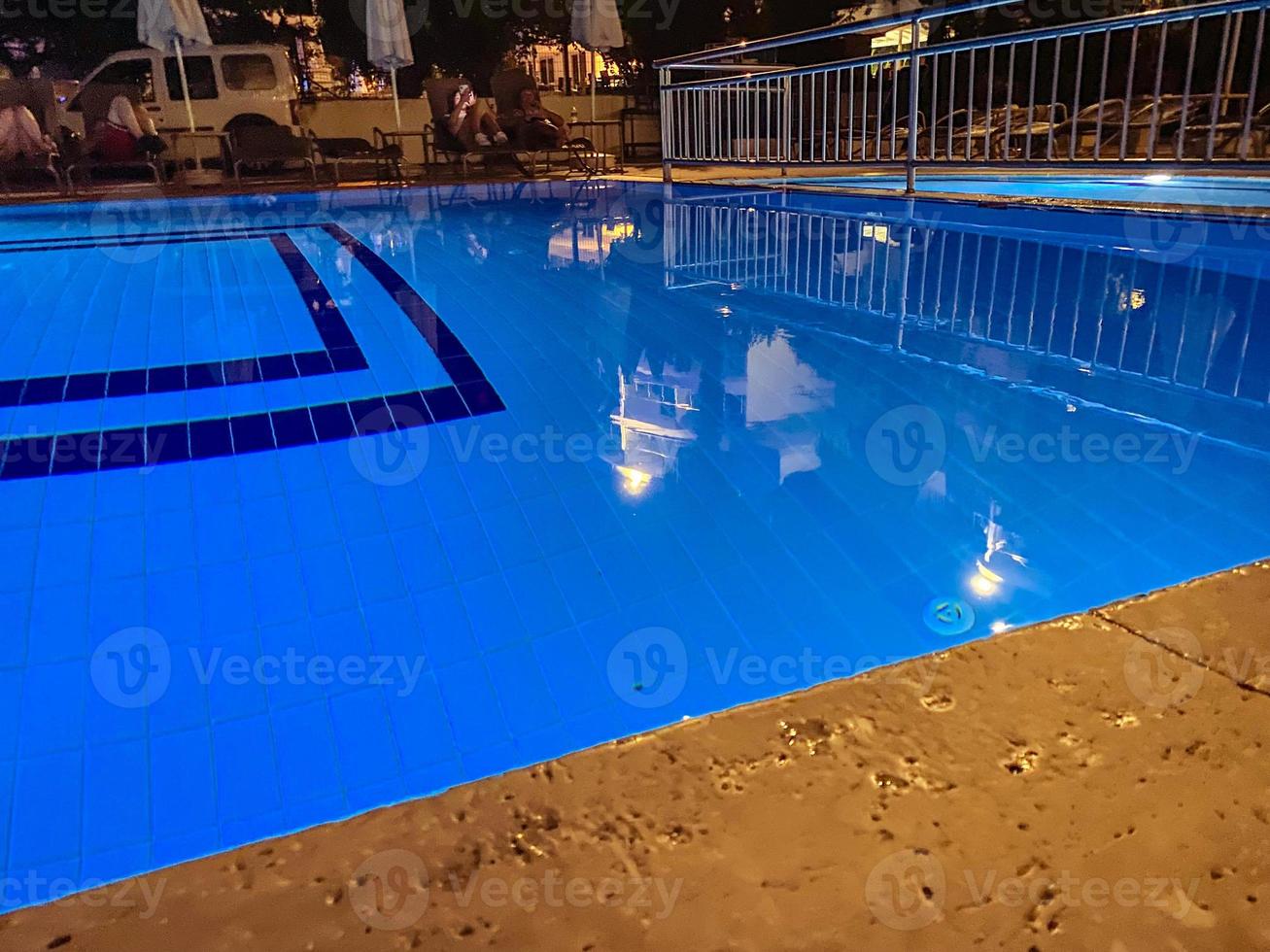 piscina en el sitio. piscina con agua azul para bañar a los residentes del hotel. borde de piedra de construcción foto