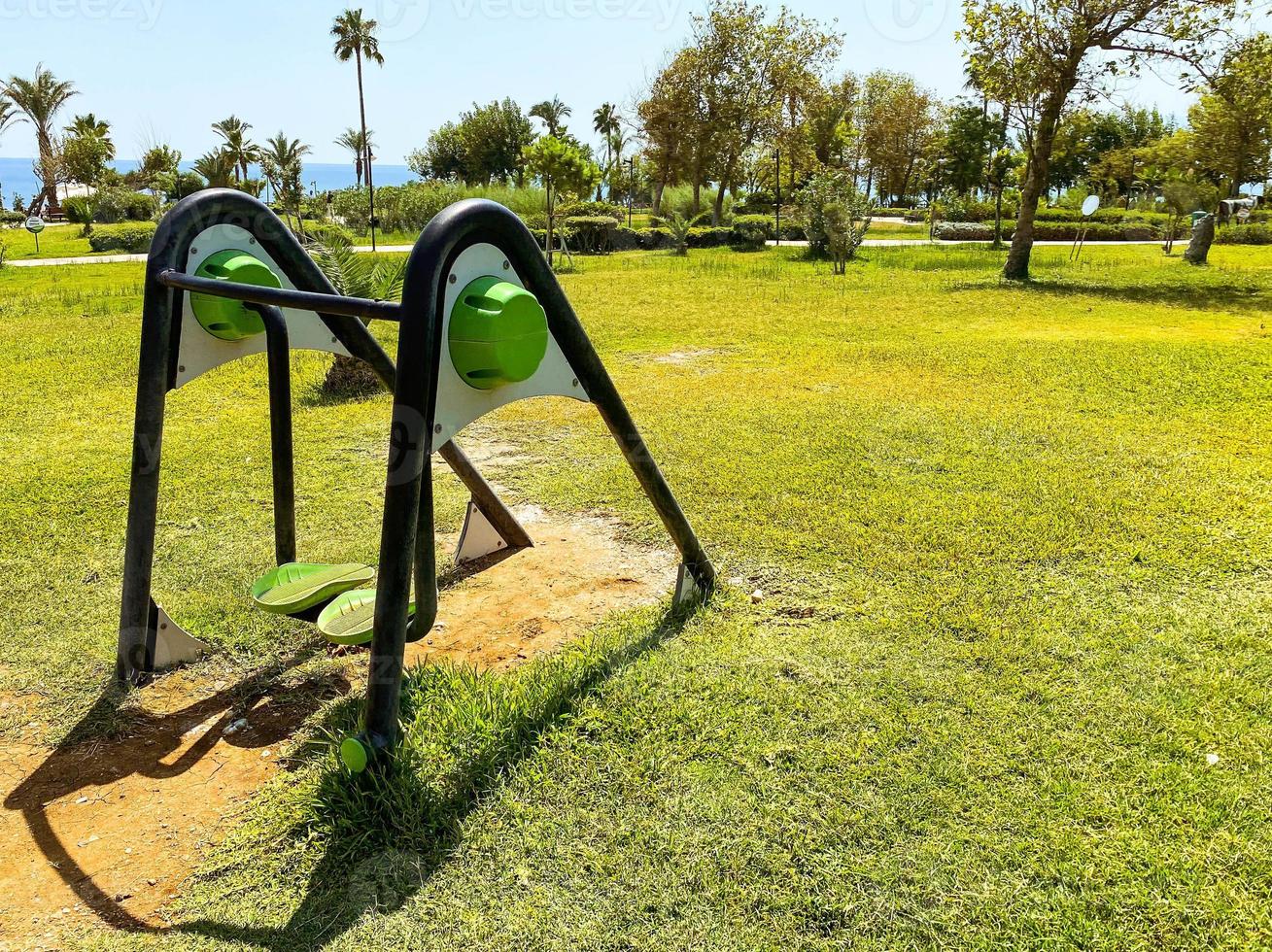 sports ground with exercise machines on the street near the sea. simulators for pumping the body and muscles. walking simulator. brisk walking, leg wiggling for weight loss photo