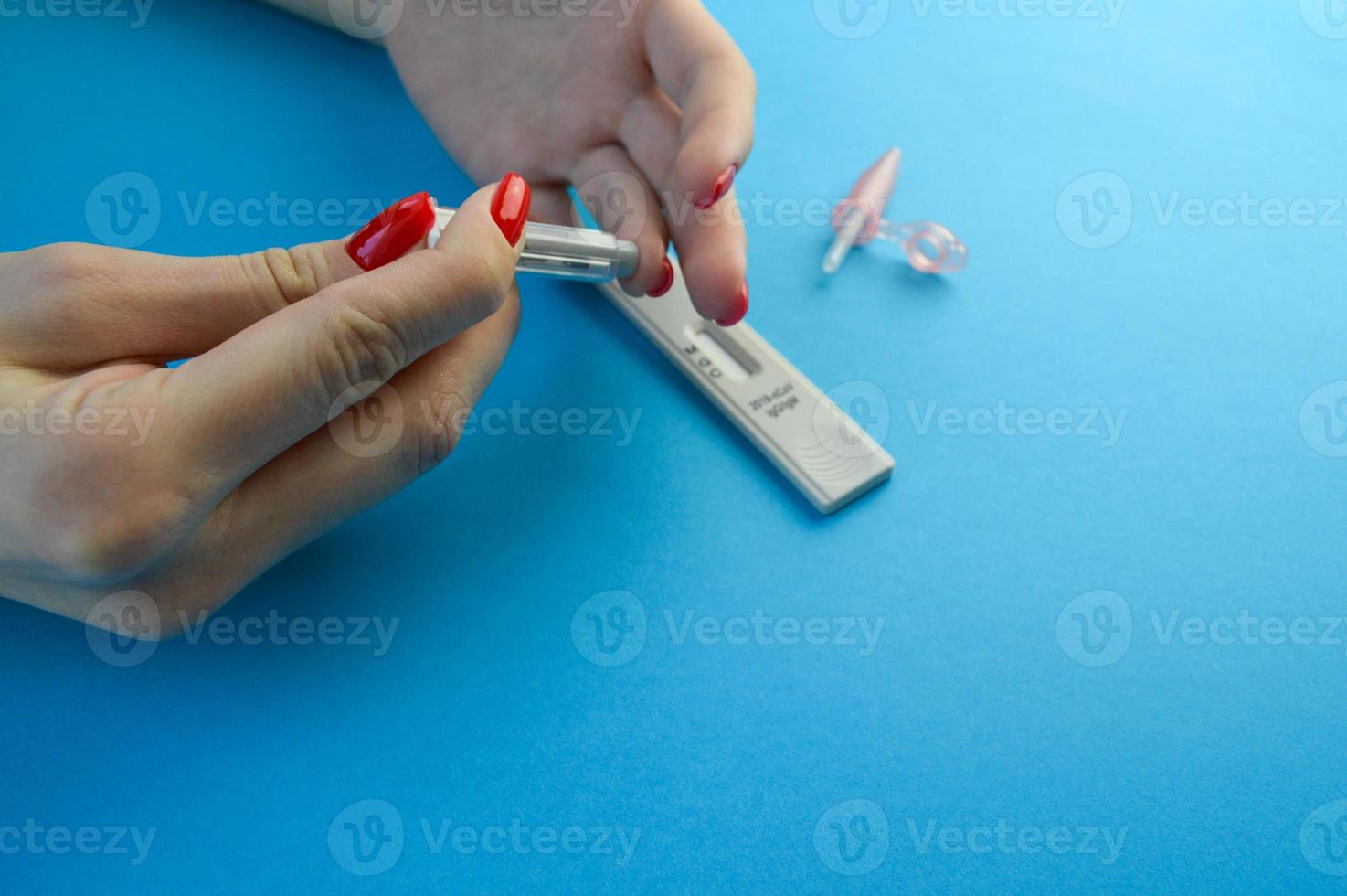 Rapid COVID-19 test for detection of specific antibodies IgM and IgG to novel corona virus SARS-CoV-2 causing Covid-19 disease. Hand holding test on blue mint background photo