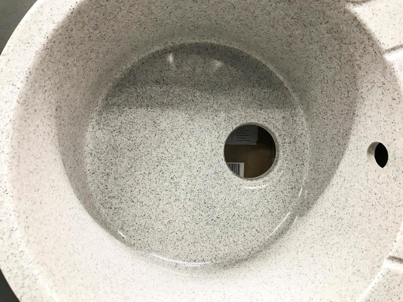 sink without faucet and drainage pipes. concrete sink with holes for water supply and drainage. sink for home, goods in a hardware store photo