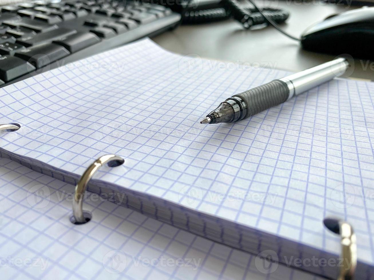 Stationery set. Levitation of notepad, pencils, pen, sticker and binder clips. Copy space on notebook and notes. Writing tools. Office supplies. Isolated on gray backdrop photo