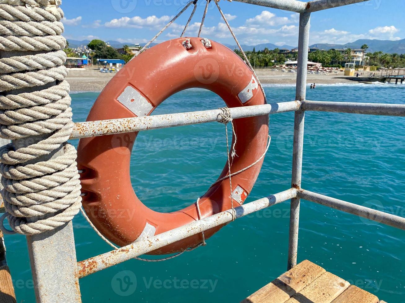 Round non-sinking red lifebuoy for safety to save the lives of drowning people tourists against the background of the sea in a warm eastern tropical country southern paradise resort photo