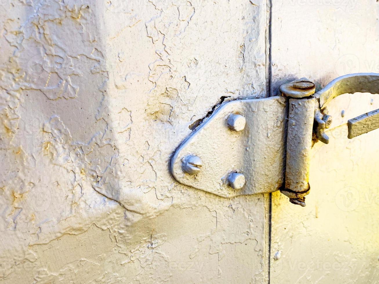 shutter of the old door to the booth. housing for builders. temporary house for people. gray metal door attached to a large hinge photo