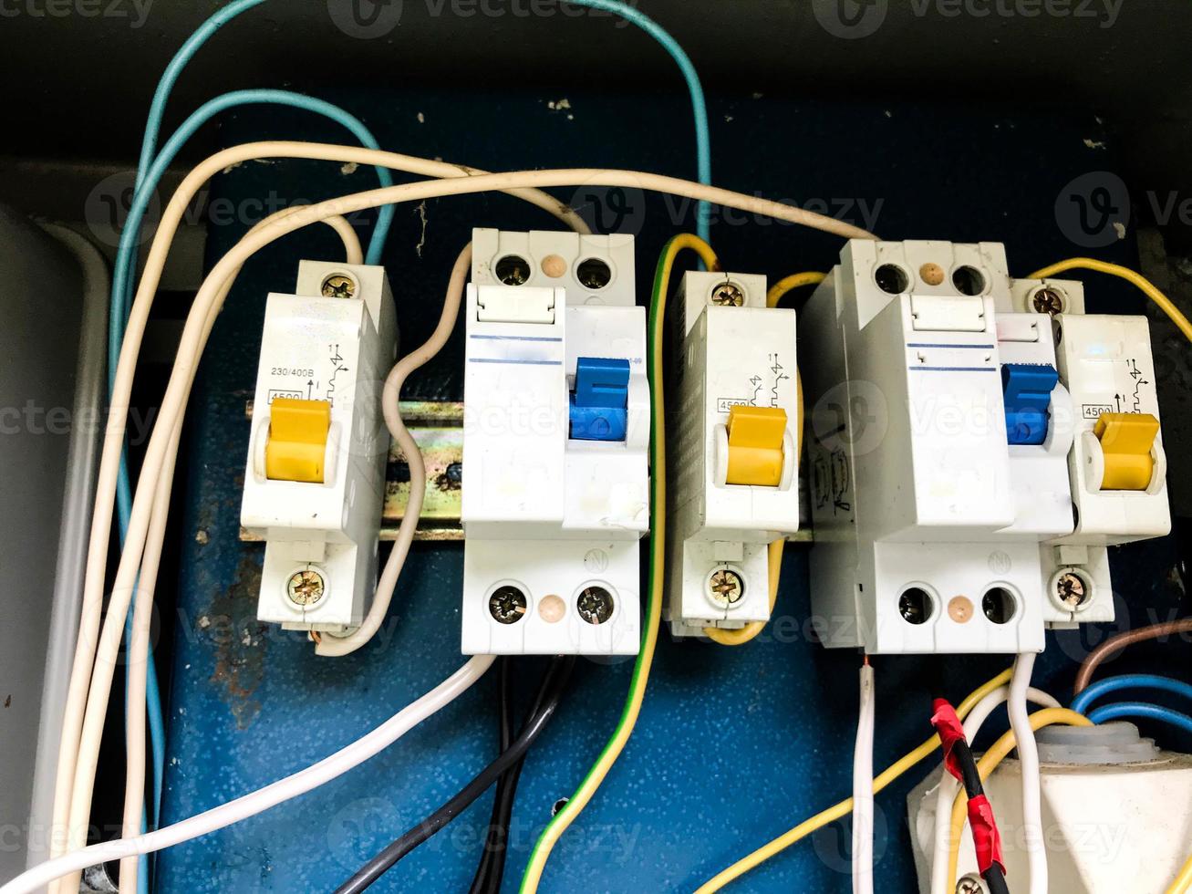 homemade electrical panel. wires and special meters in white. switches, automatic machines in blue and yellow. wires for connecting parts of the meter photo