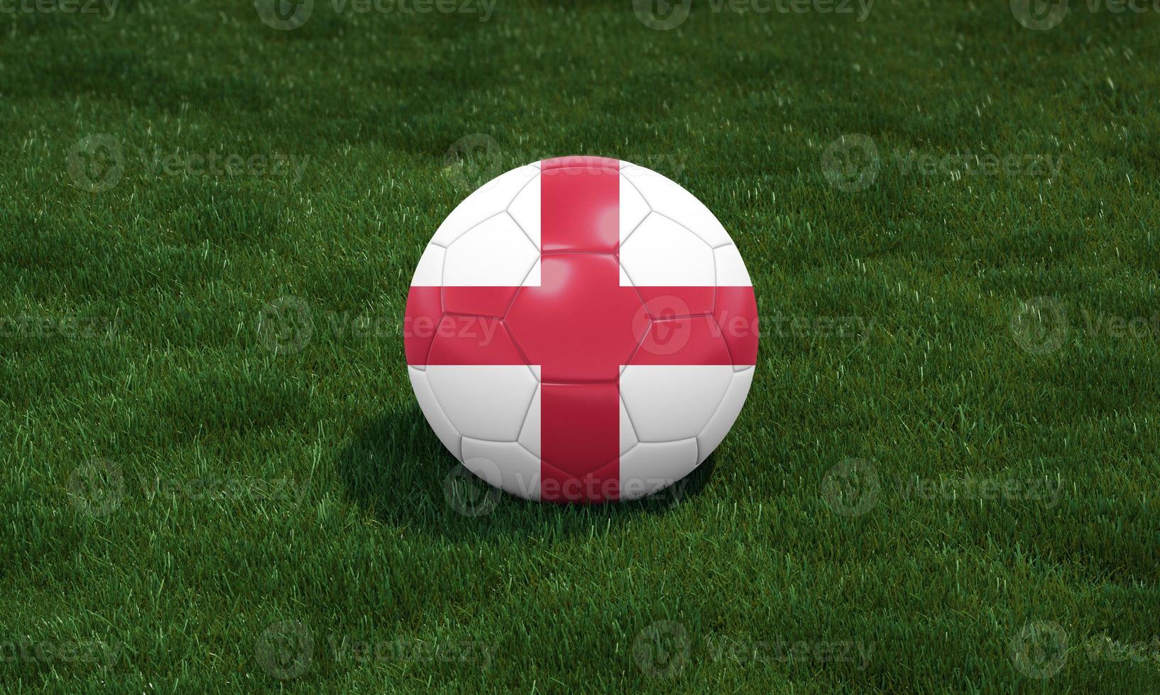 Soccer ball with England flag colors at a stadium on green grasses background. photo