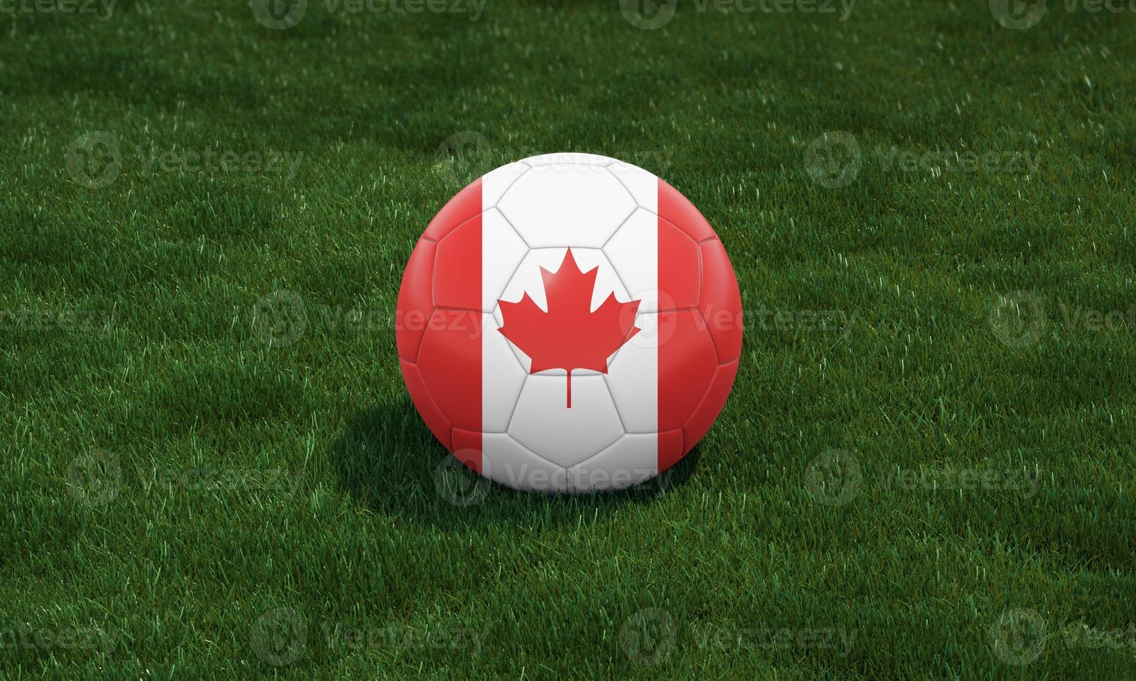 Soccer ball with Canada flag colors at a stadium on green grasses background. photo