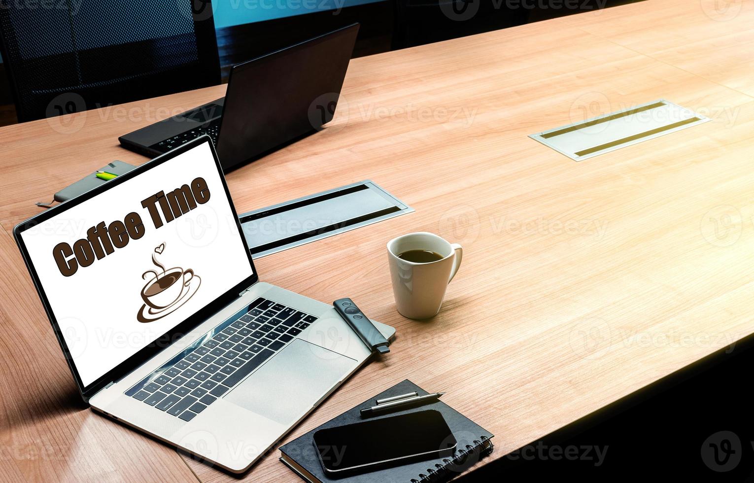 Coffee time message and icon coffee cup on display laptop with coffee cup on table in meeting room photo