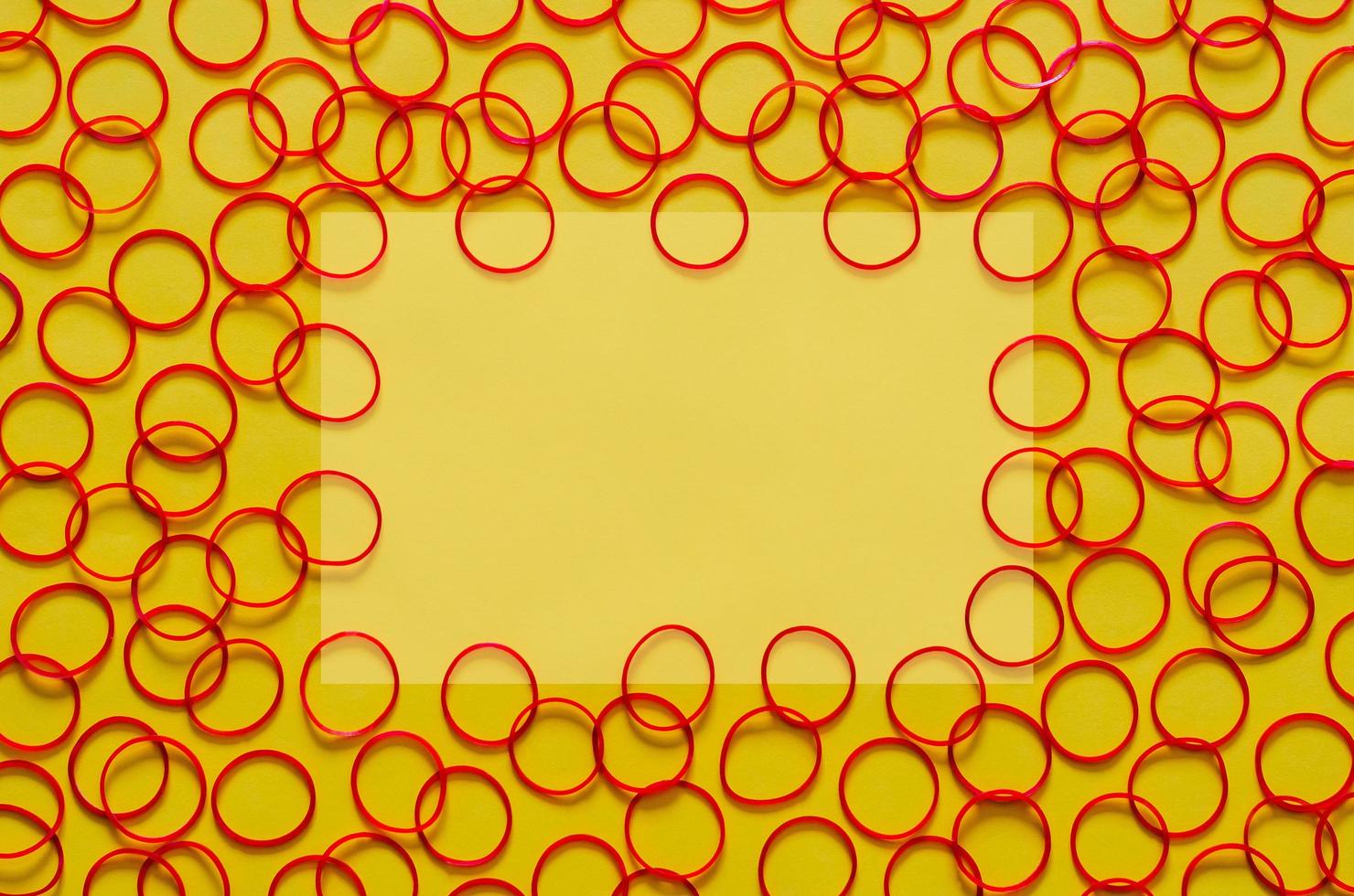 Red color elastic rubber bands put on yellow background with empty space for background and abstract concept. photo