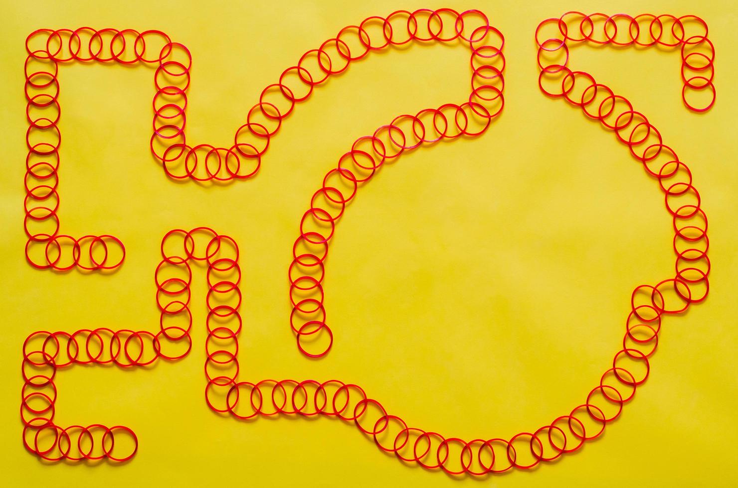 Red color elastic rubber bands arrange in line shape put on yellow background with empty space for background and abstract concept. photo