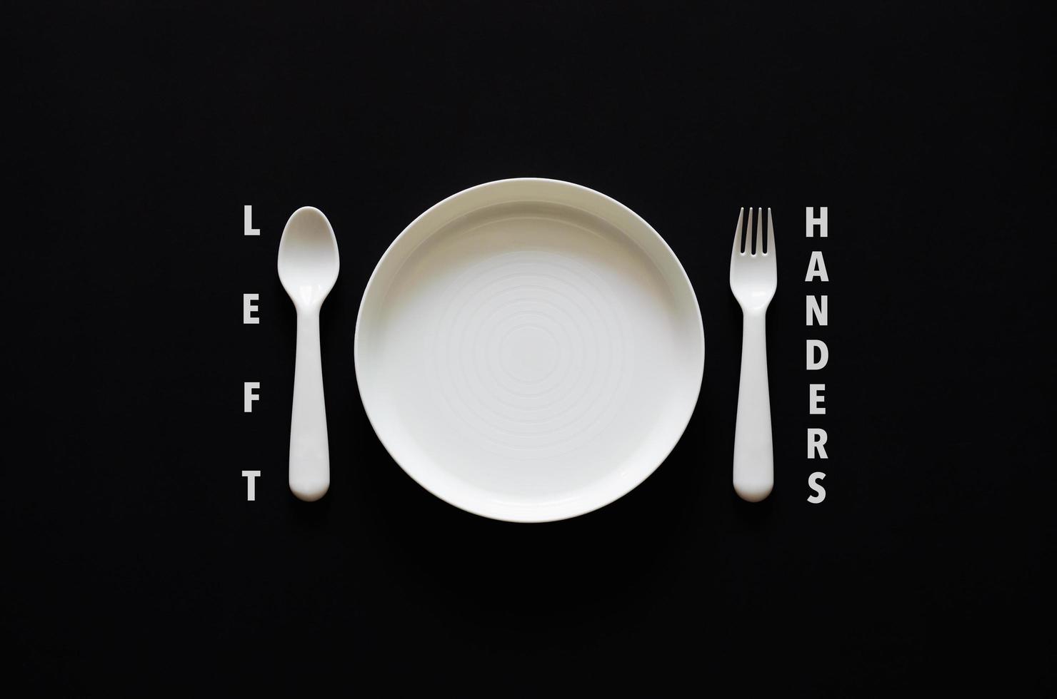 Spoon put on left side of the dish on black background for International left handers day concept photo