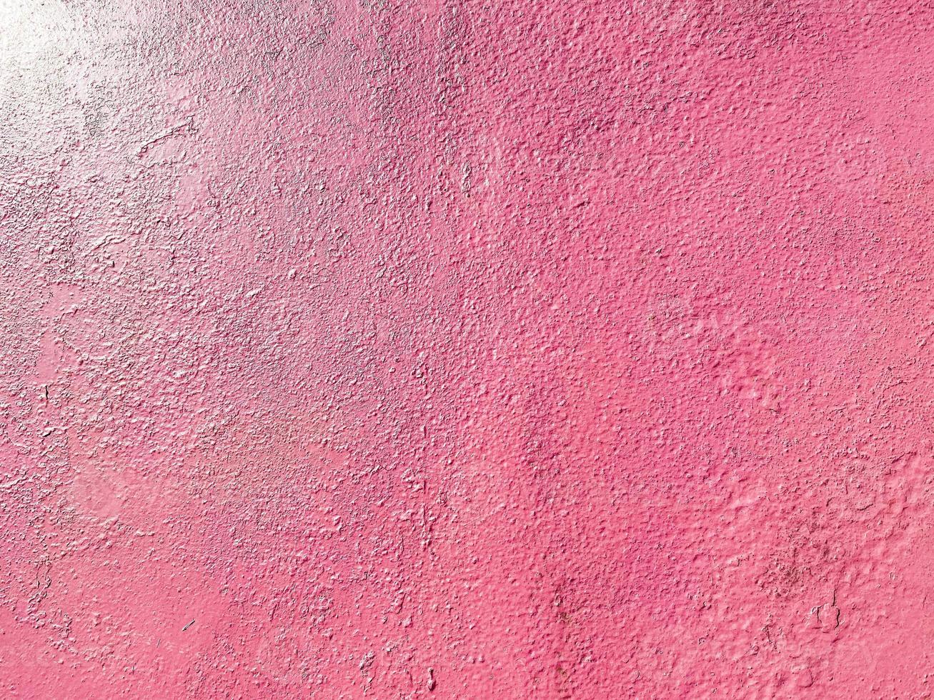 textura roja rosada de una antigua pared de hierro metálico pintada con grietas y abrasiones. el fondo. textura foto