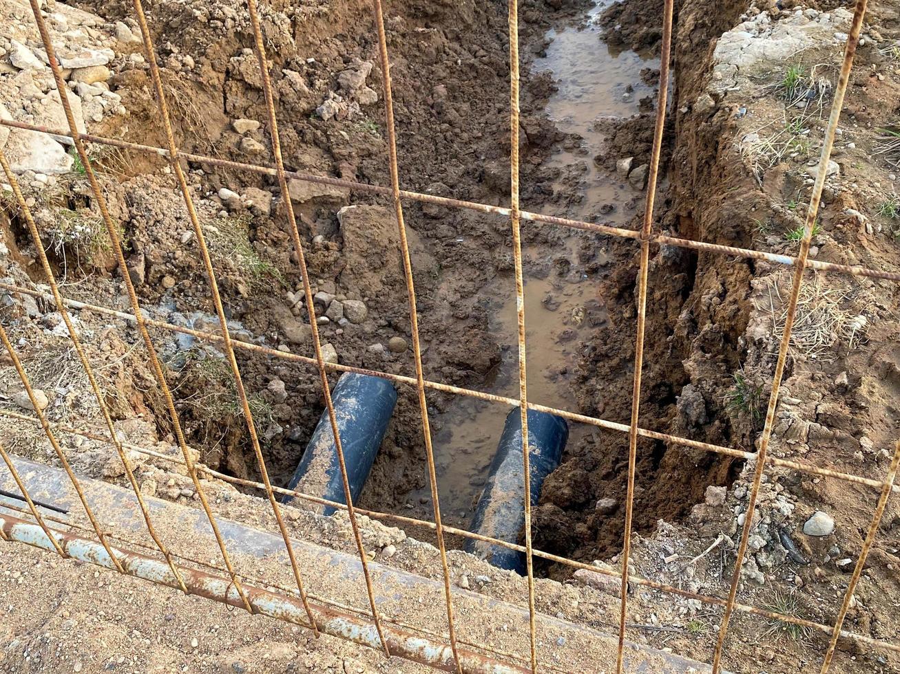 An excavated pit is a ditch for laying cables and wires with pipes under the ground during the construction and repair of houses in the city of the megalopolis photo