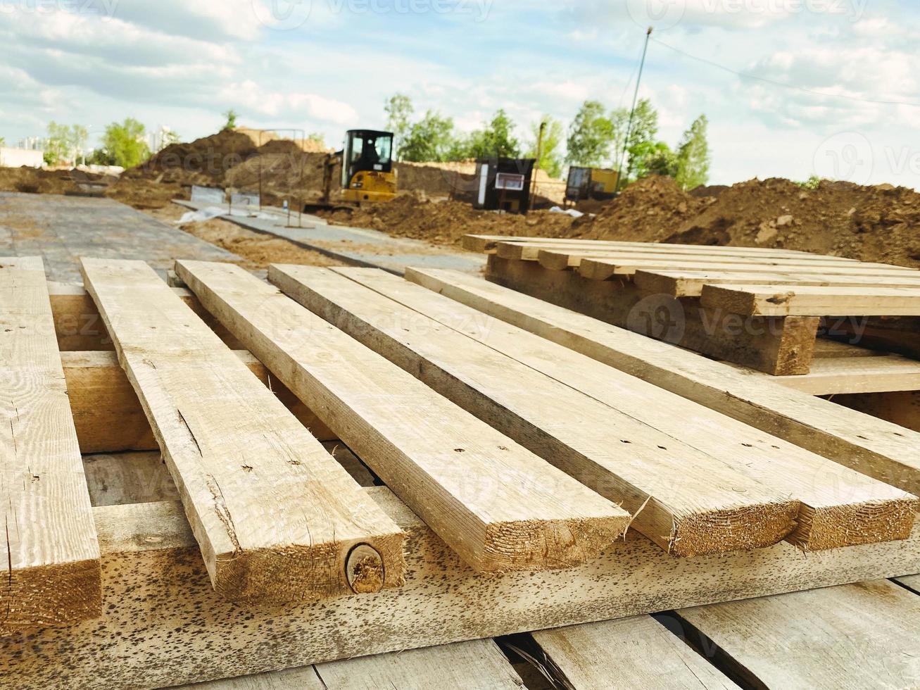 paletas de madera en el sitio de construcción. material natural para llevar objetos pesados en el sitio de construcción. paleta hecha de amarillo con una superficie lisa foto