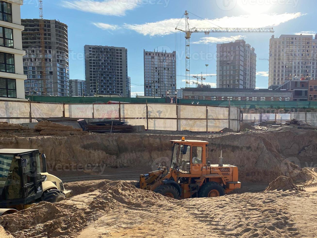 Tower cranes in action at construction site. Construction process of the new modern residential buildings. Road work and streets repair in city. Preparing to pour of concrete into formwork photo