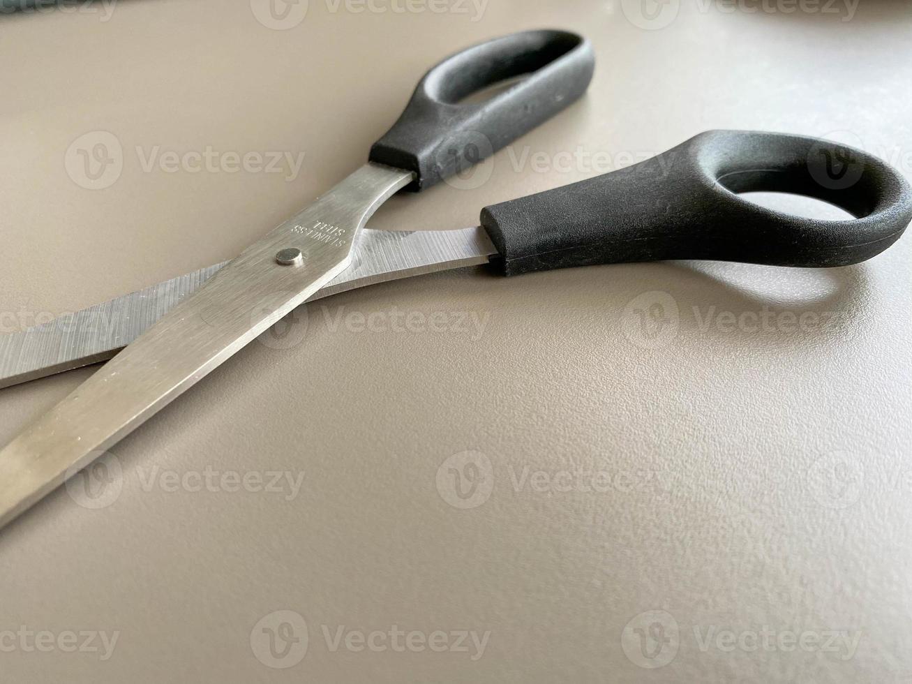 Black scissors on yellow wooden background. Top view. Copy space for text or design photo