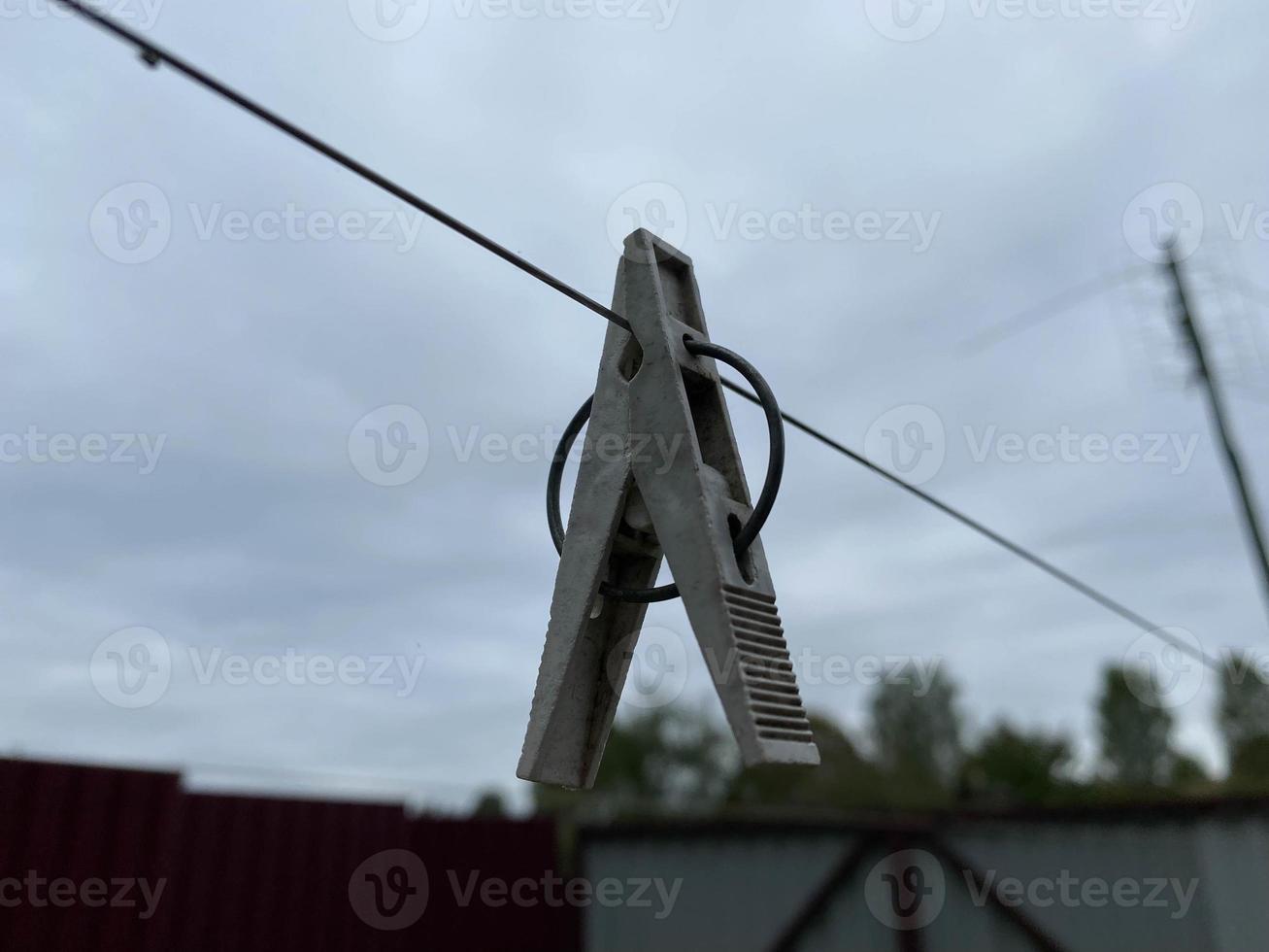 Colorful clothespins on a clothesline against the sky and grass photo