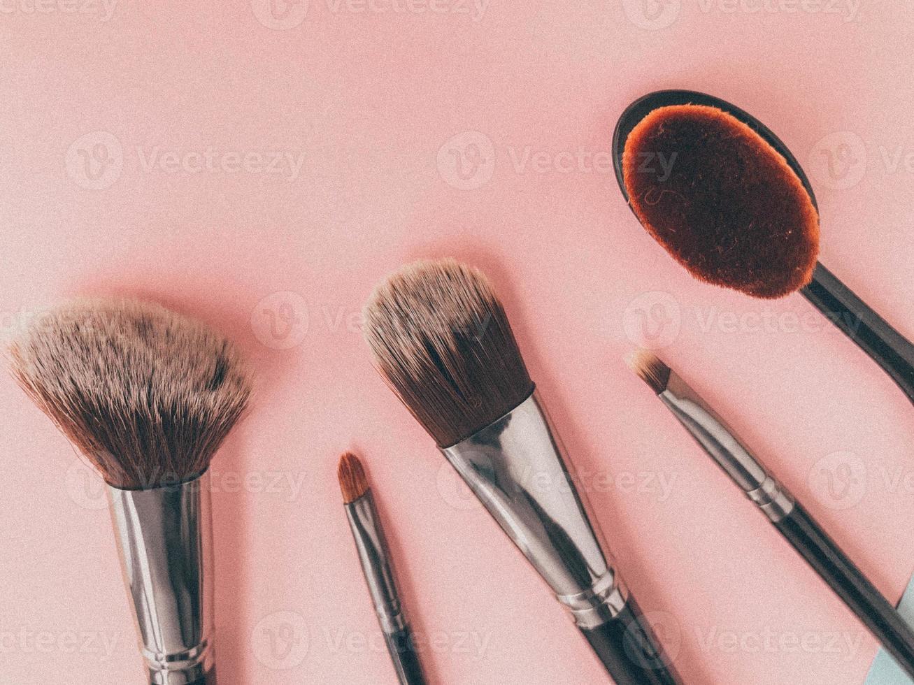 brushes on a pink background. makeup artist tool. brushes for powder, foundation and contouring. a brush for blending cosmetics over the face. modern makeup photo