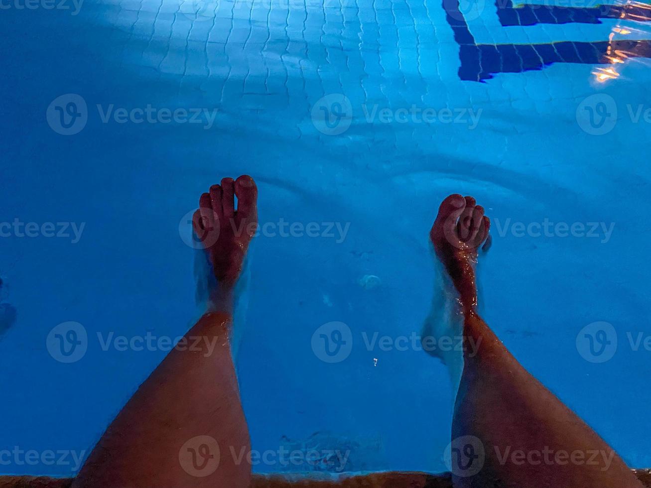 Relaxing at the swimming pool. Man relaxing next to swimming pool. Man enjoying the hot summer photo