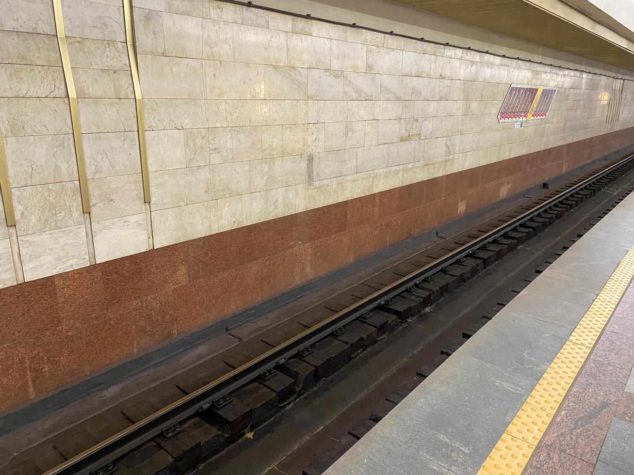 vista del túnel en la plataforma para esperar trenes en la estación de metro con paredes de granito foto