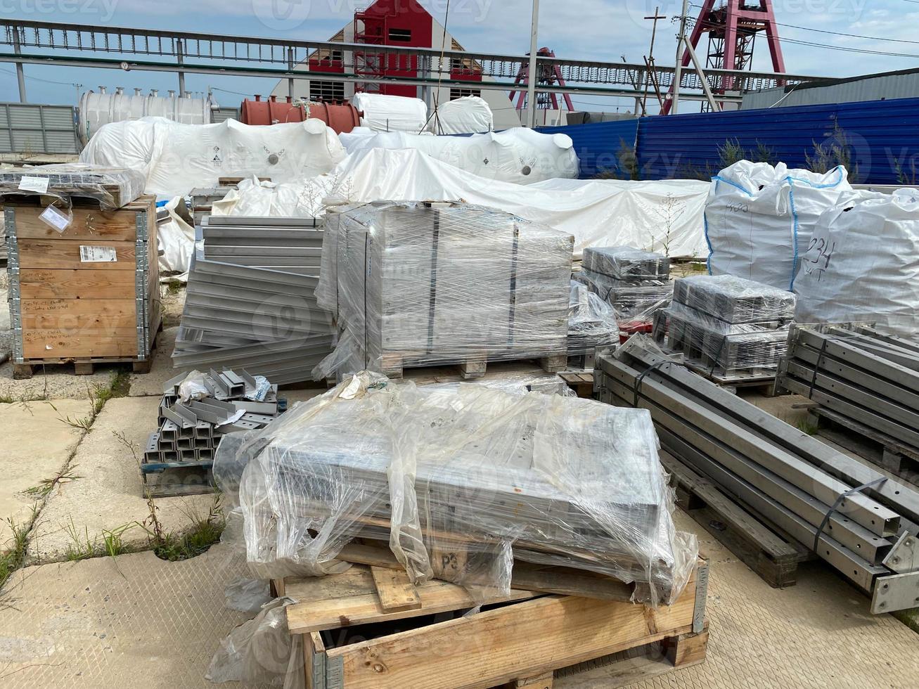 estructuras metálicas para la construcción y tuberías sobre paletas en un almacén al aire libre para el almacenamiento de materiales y equipos industriales foto