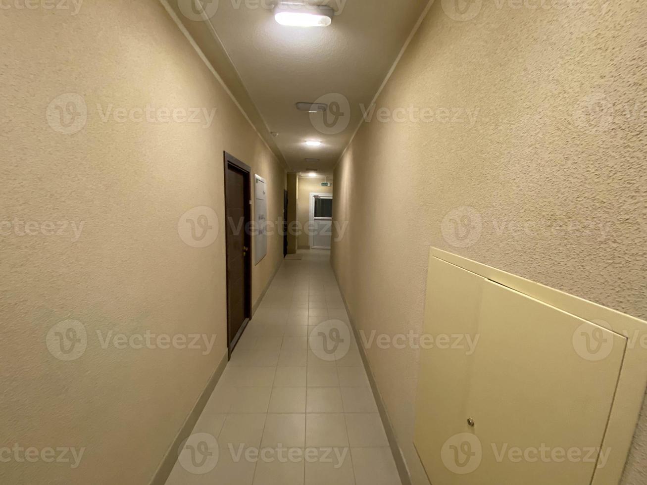 Corridor of new residential building under construction view. Aerated concrete blocks house corridor walls under construction ready for plastering, stucco. Long and narrow corridor with elevator door photo