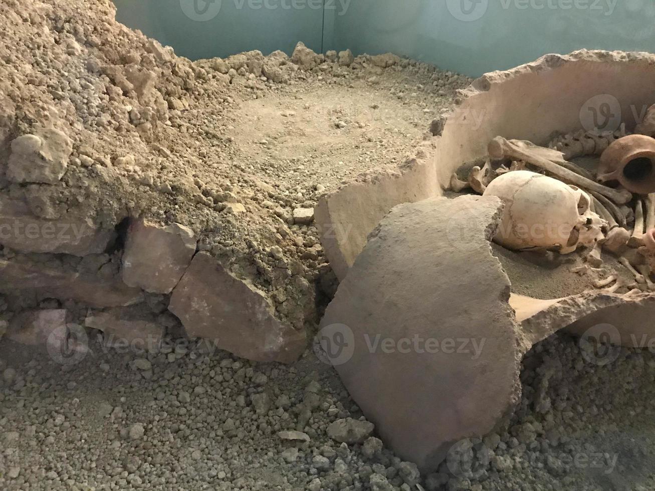 Old human skeleton in ancient tomb at archaeological excavation photo