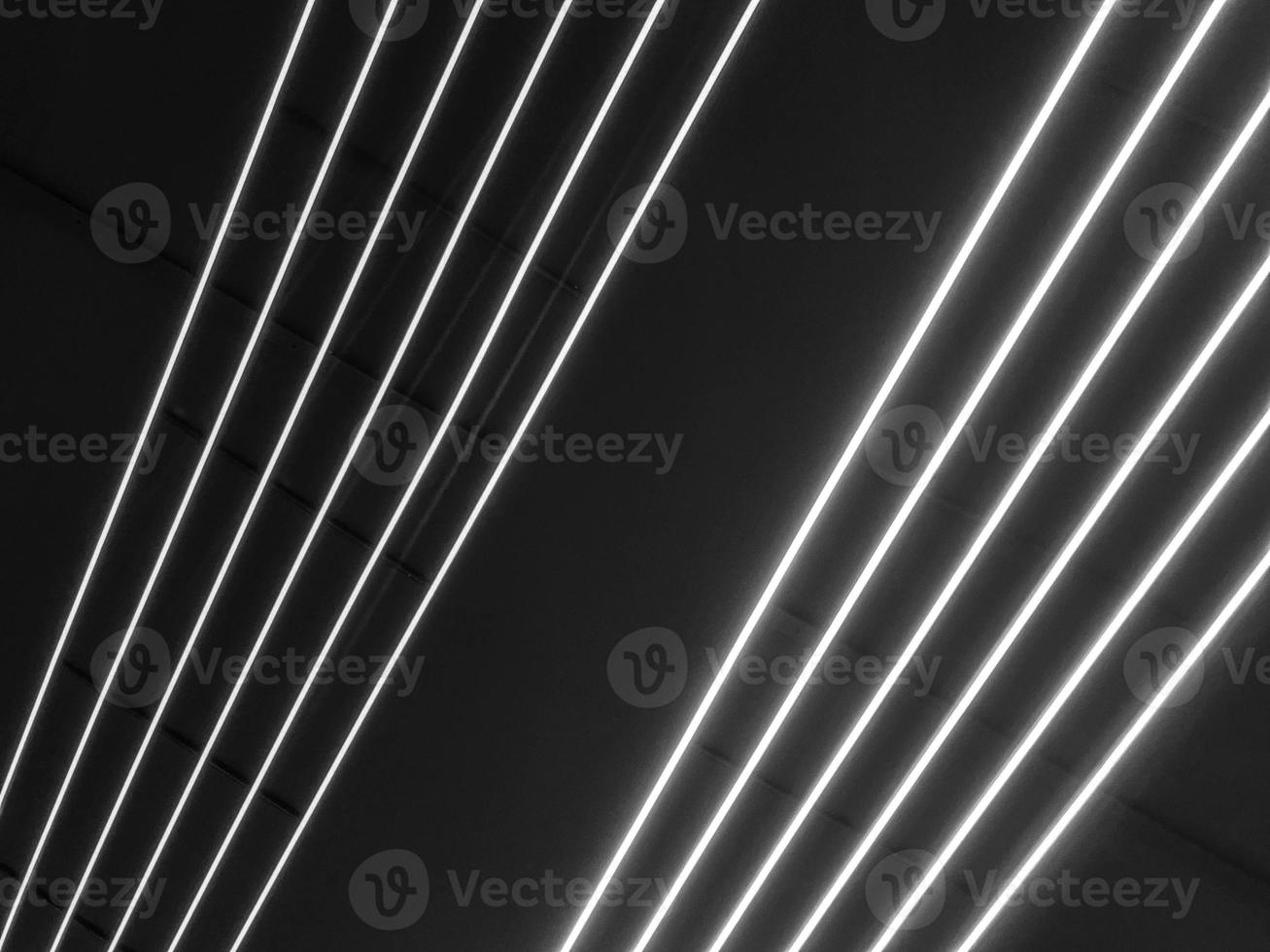 Texture of black and white glowing bright neon LED multicolored laser abstract stripes and lines from parallel lamps. The background photo