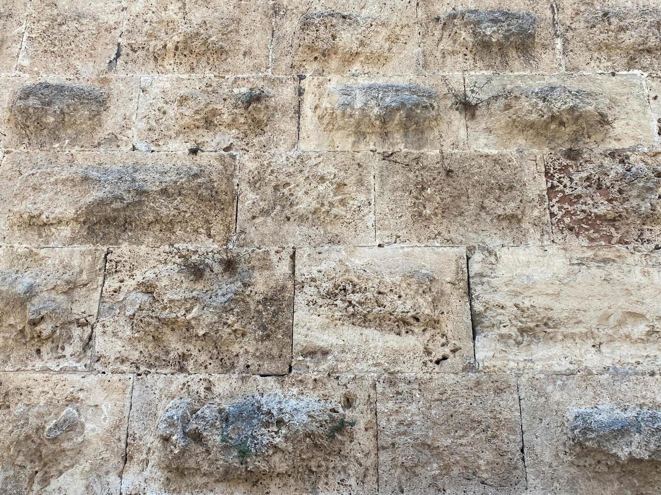 textura de un muro de piedra hecho de grandes bloques. elementos del edificio de la antigüedad antigua foto