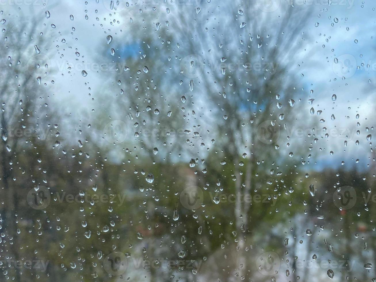 Beautiful surface texture of wet transparent glass in a window with clean cold drops after rain. The background photo
