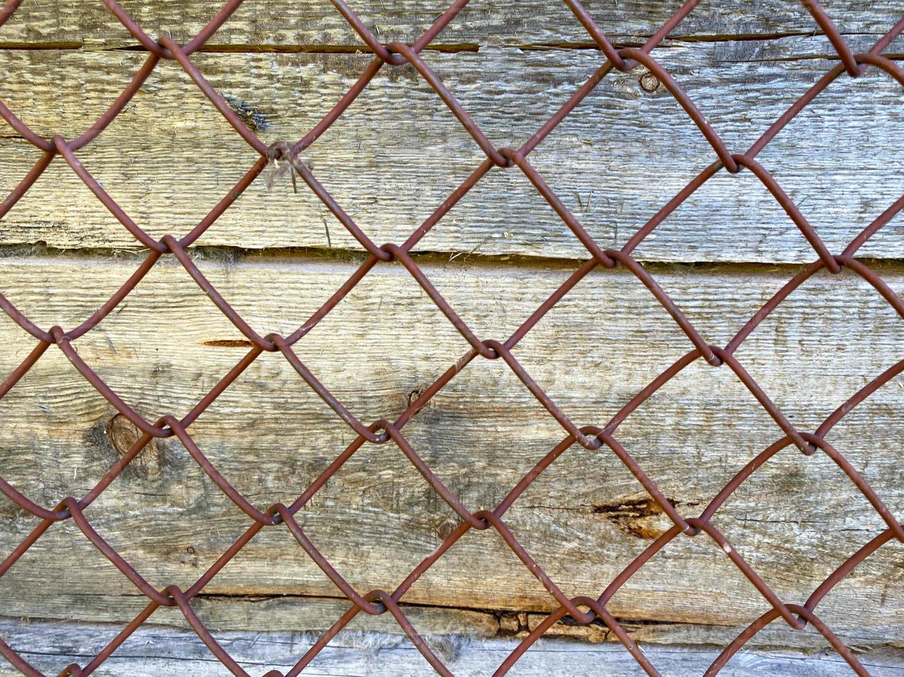 textura de madera marrón de madera natural de tablones verticales con nudos. fondo y malla de malla de hierro foto