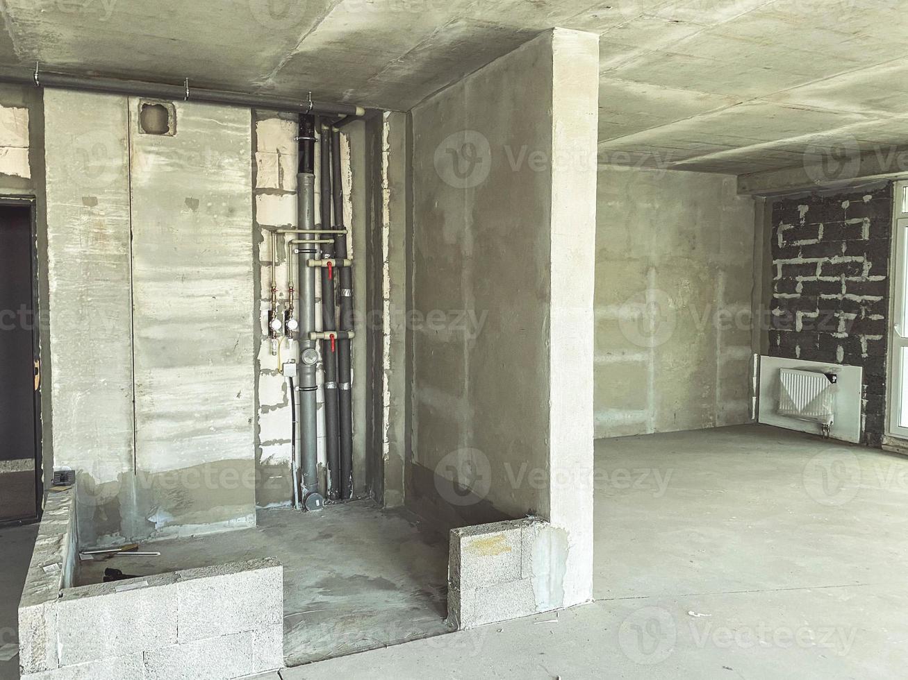 new building, construction of an apartment from brick and concrete, blocks. unfinished housing. a new apartment for people's lives. plumbing pipe stand photo