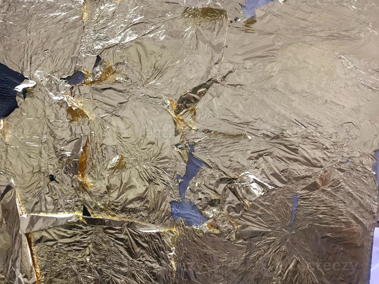 Gold glittering bright yellow metallic gold leaf texture for artistic purposes and creativity. The background photo