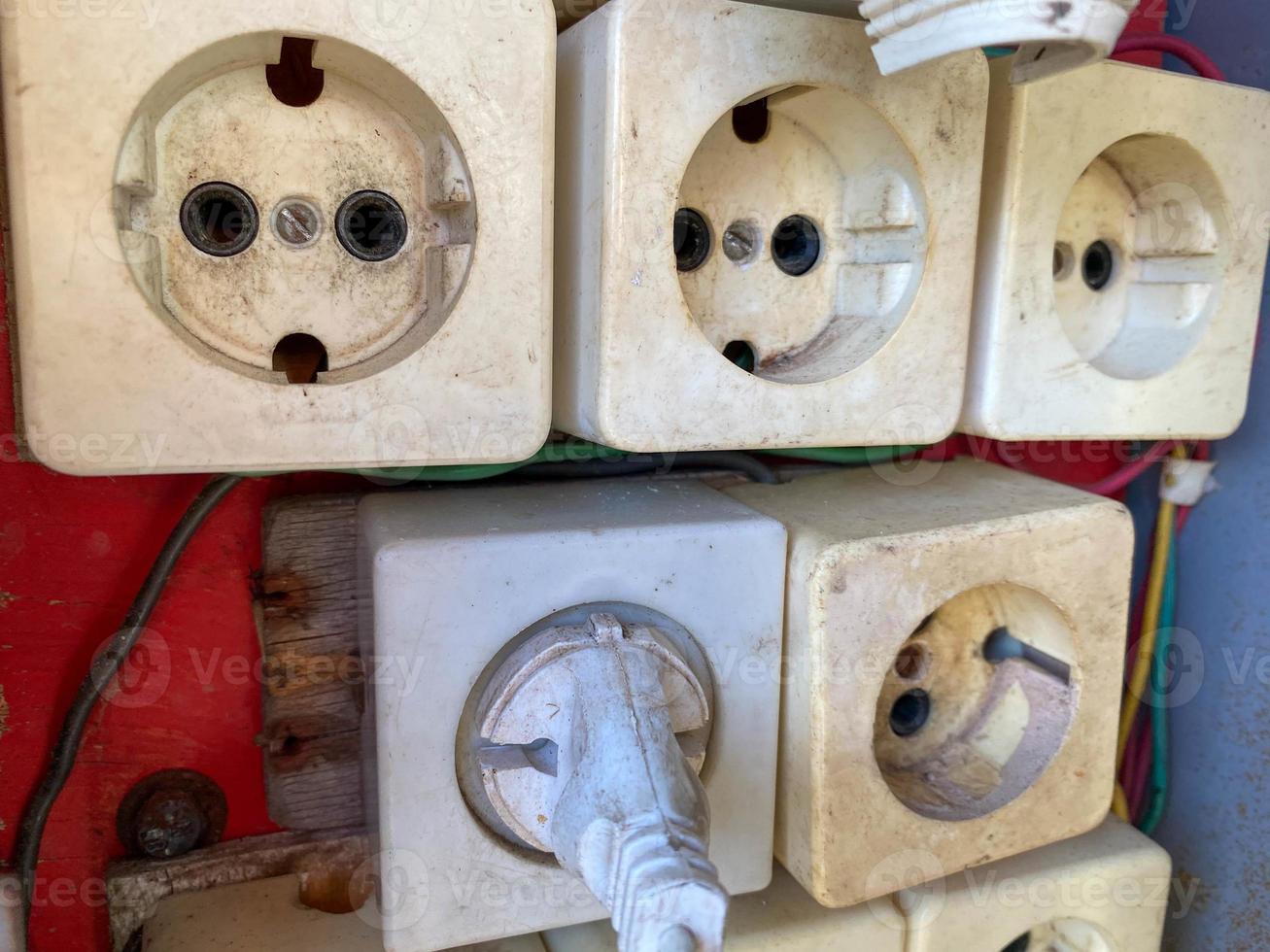 Large white unprofessionally installed many square electrical outlets in an electrical panel photo