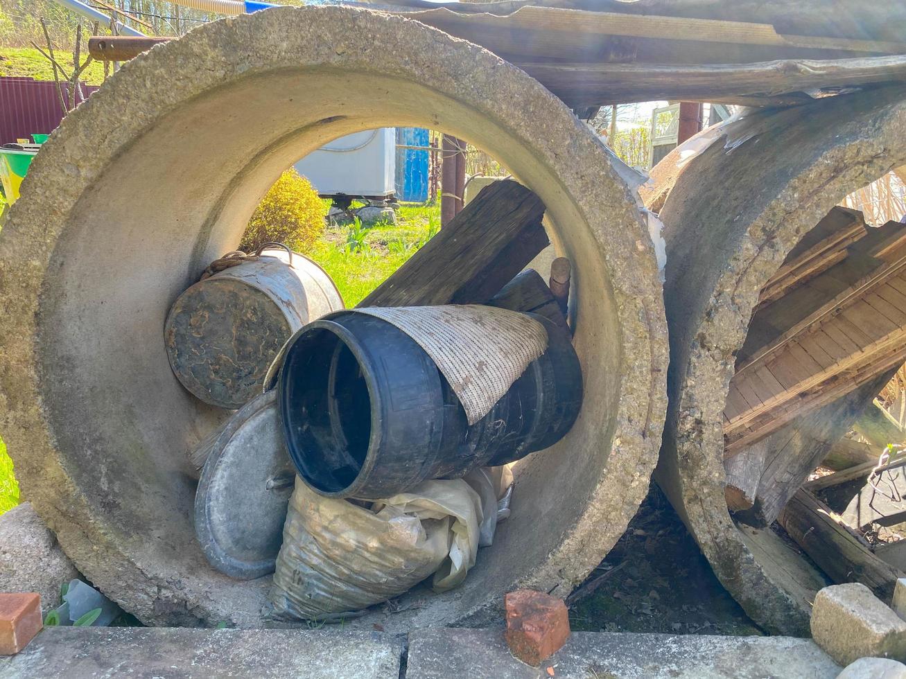 Large concrete cement construction rings for a well or sewer with industrial debris inside photo