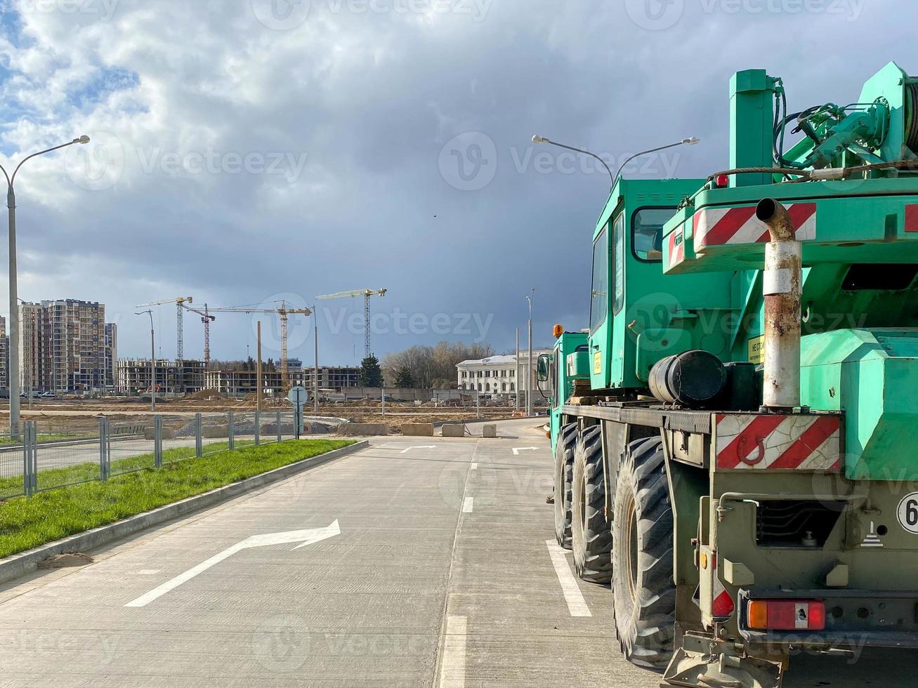 Large powerful new industrial green construction crane used in the construction of new areas of the city. Special construction equipment photo