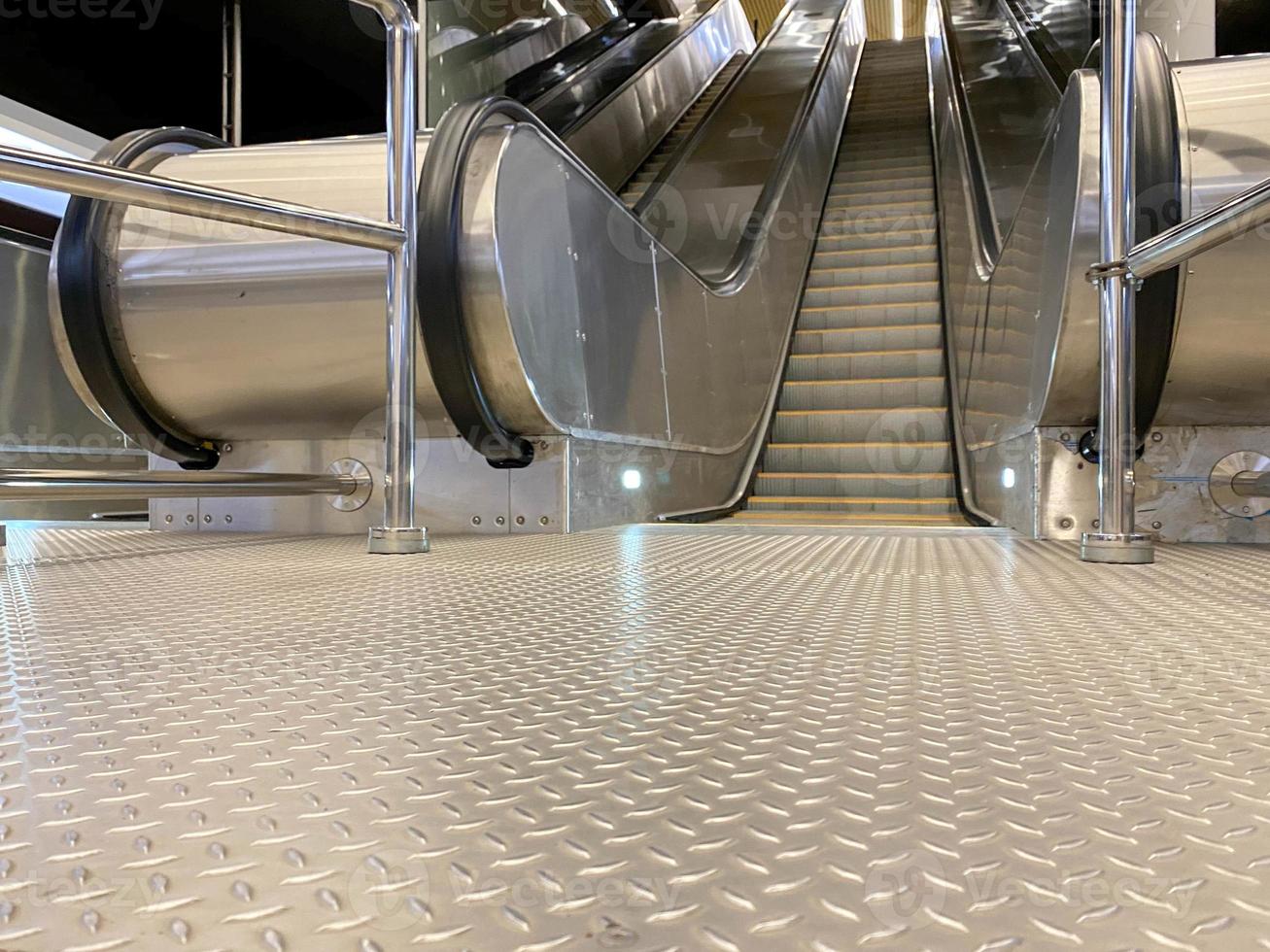 Large comfortable fast metal modern escalators with automatic steps for going up and down the subway or shopping and entertainment center photo
