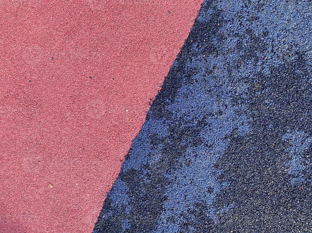 Blue and pink rubber surface anti-traumatic safety tile for workout sports playground in public park or courtyard. The background. Texture photo