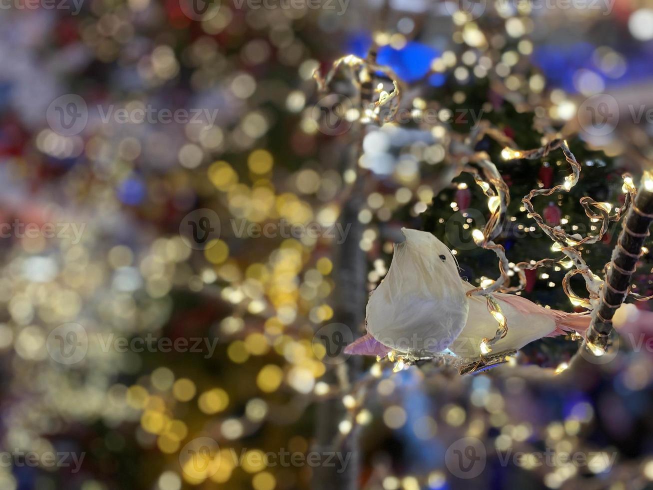 Christmas tree with Christmas toys small bird, cones, balls, colored lights. Concept New Year, greeting card, celebrat photo