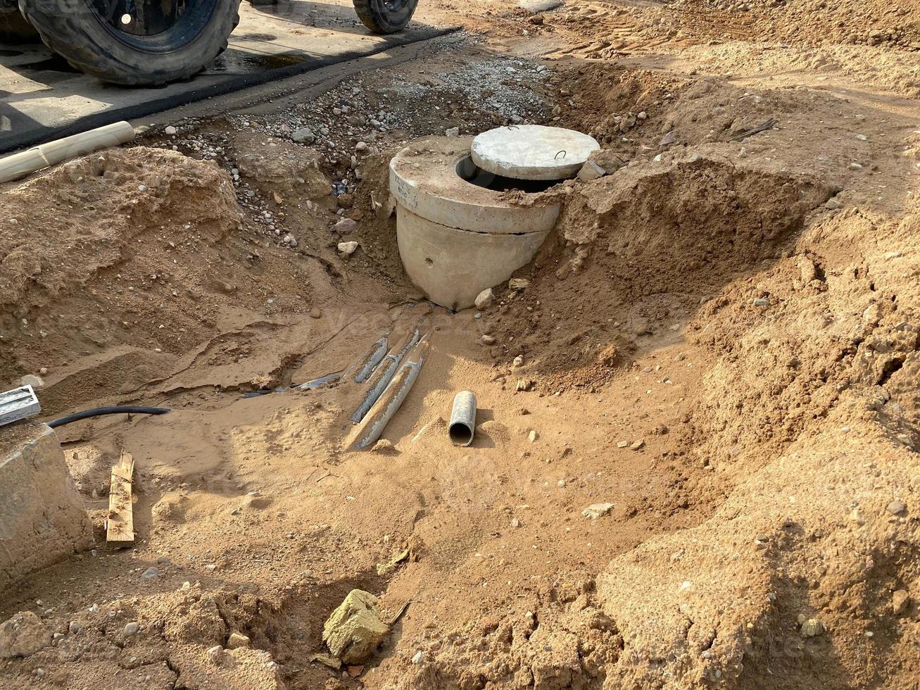 Concrete manhole in a pit at a construction site. Industrial construction of sewerage engineering networks photo