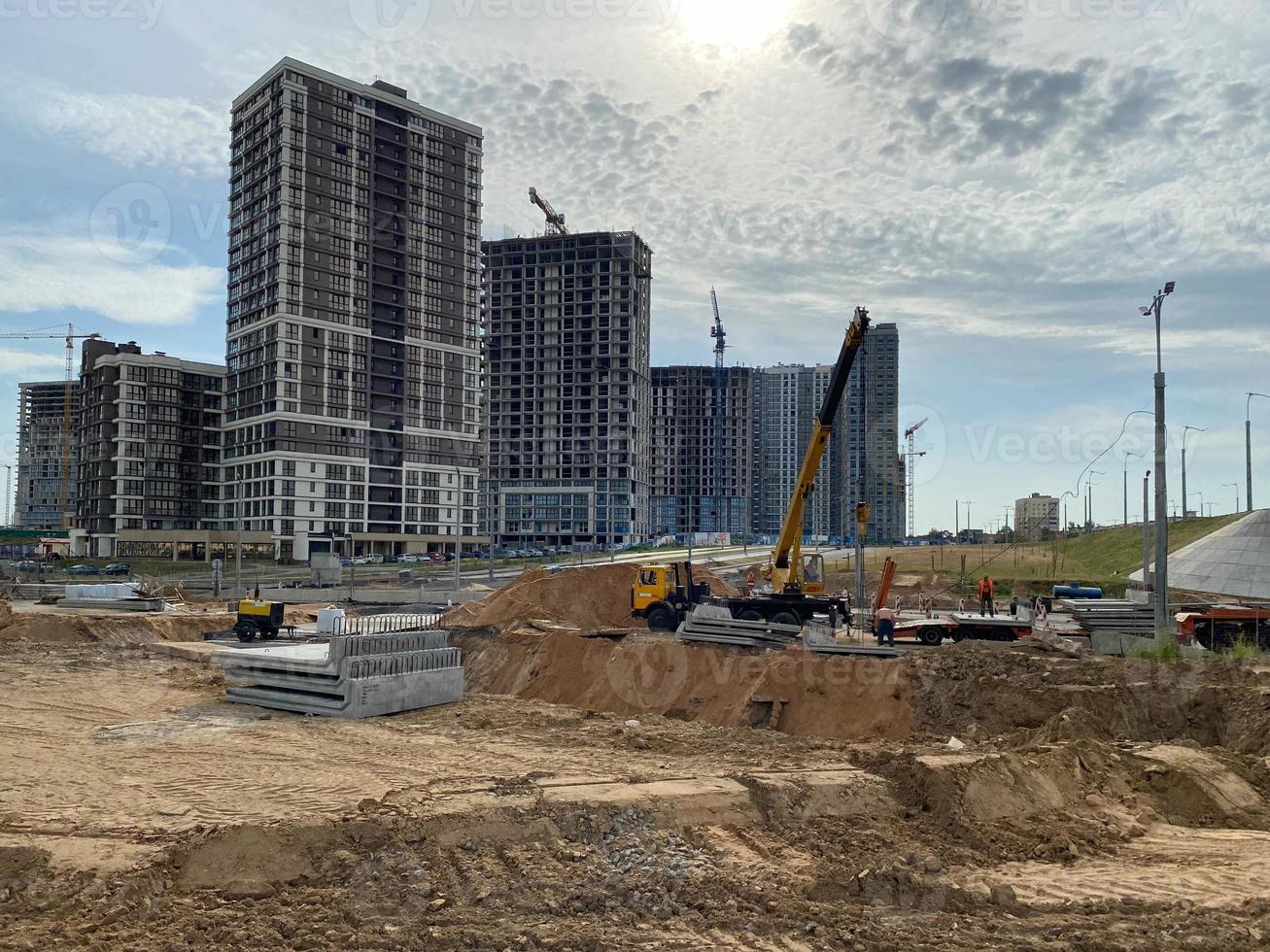 los edificios y las casas altos, modernos y hermosos son rascacielos de hormigón construidos industrialmente utilizando tecnología de marco monolítico con la ayuda de equipos de construcción y grúas foto