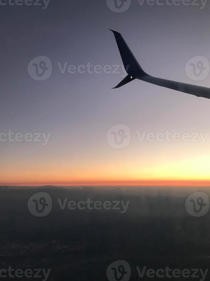 Golden sunset sky with fluffy ornamental cumulus clouds, panoramic view from an airplane, wing close-up. Dreamlike cloudscape. Travel, tourism, vacations, weekend, freedom, peace, hope concepts photo