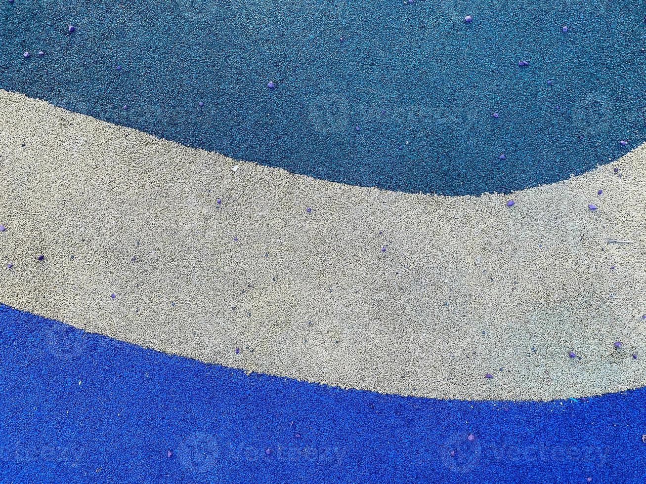 Blue and white texture of the soft rubber surface of the safe cover of the sports playground for workout made of pressed fine rubber. The background. Texture photo