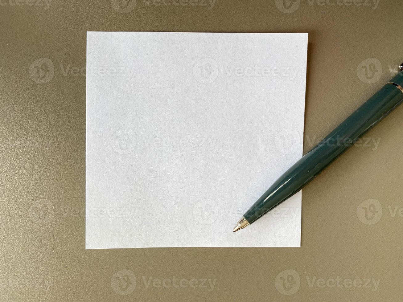 Small square pieces of paper for notes and notes on the office desk and a green ballpoint pen. Business work photo