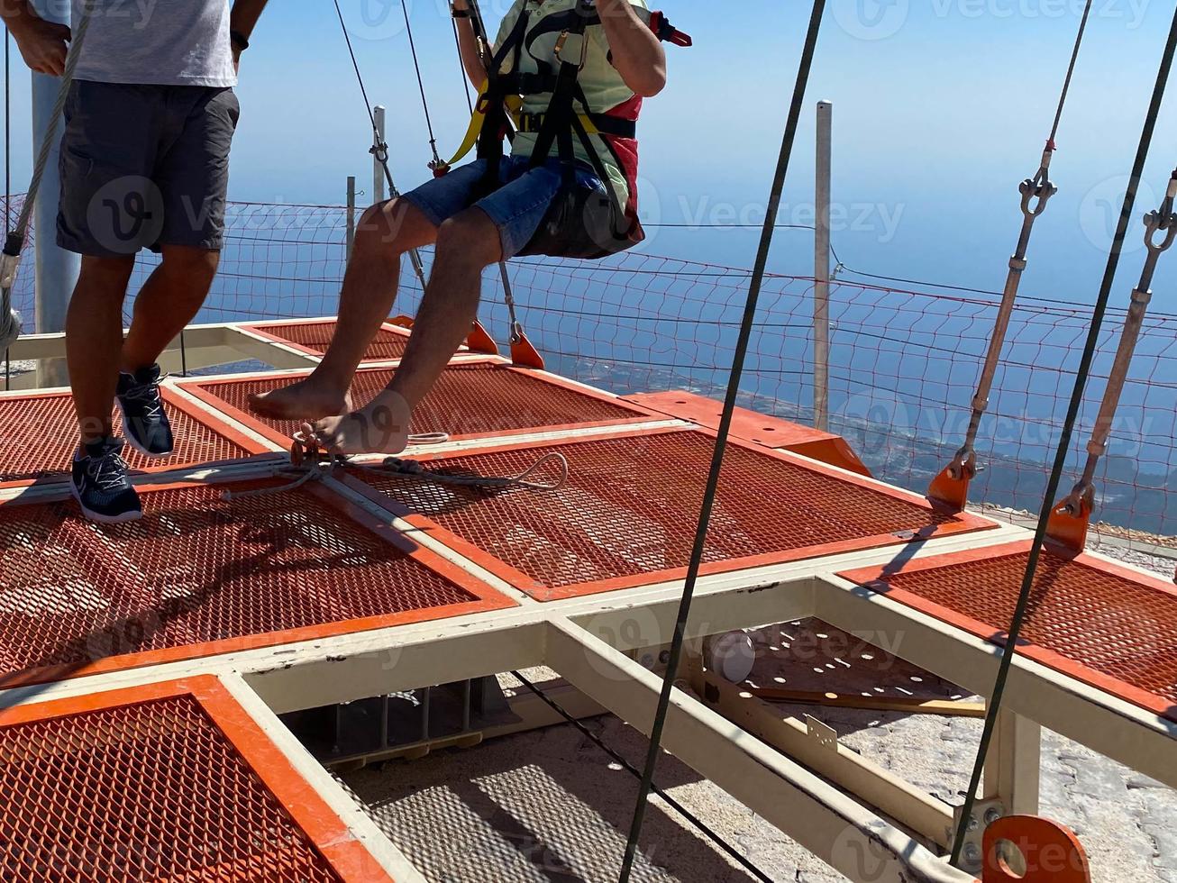 The instructor prepares a person for an extreme jump on a rope or elastic band from a great height. Extreme sport rope jumping photo