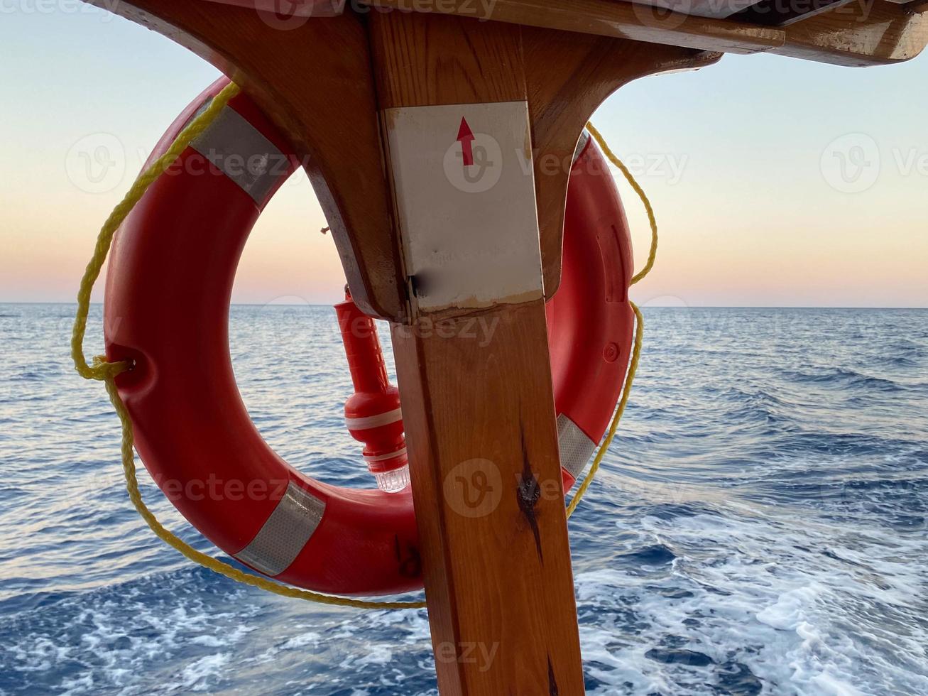 boya salvavidas. aro salvavidas rojo en una barandilla de crucero foto